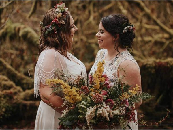 A bride with soft curtain bangs and loose waves, wearing a floral crown