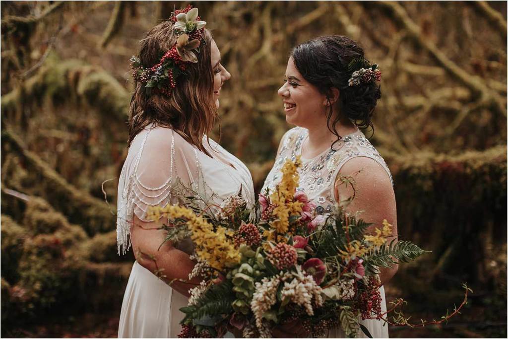 A bride with soft curtain bangs and loose waves, wearing a floral crown