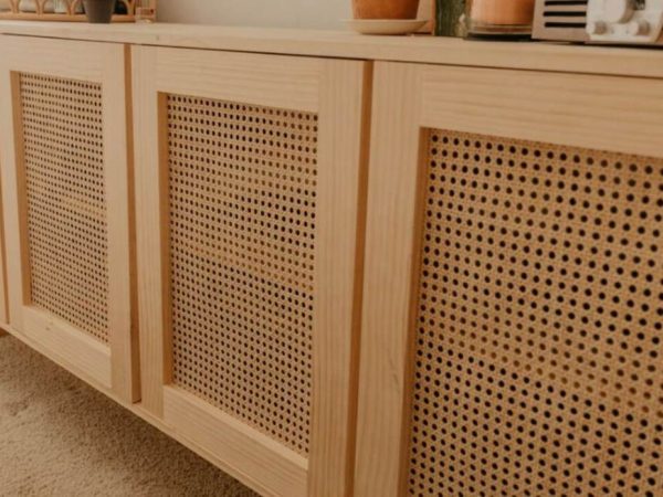 DIY cane cabinet door makeover in progress with staple gun and utility knife on a workbench