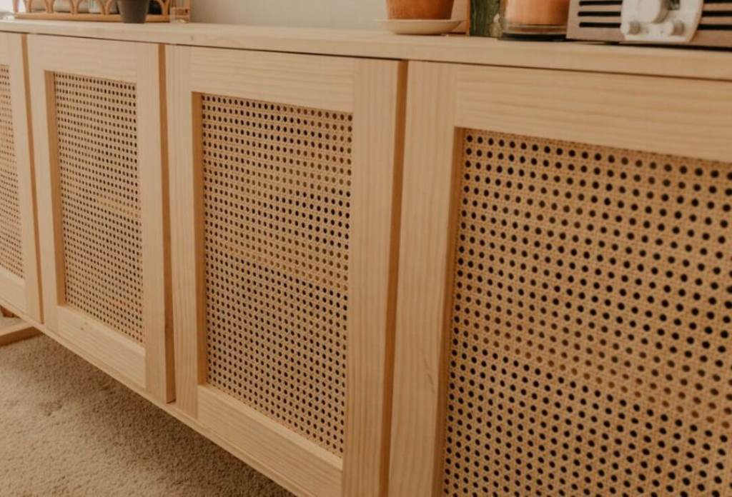 DIY cane cabinet door makeover in progress with staple gun and utility knife on a workbench