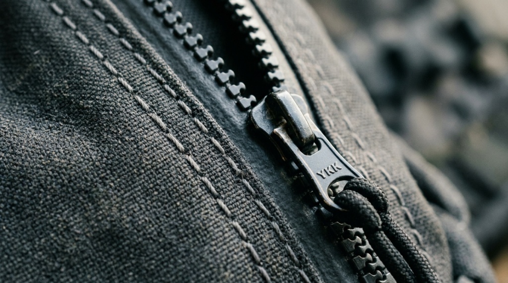 Open travel duffel bag packed with a laptop, jacket, and tech pouch viewed from above.